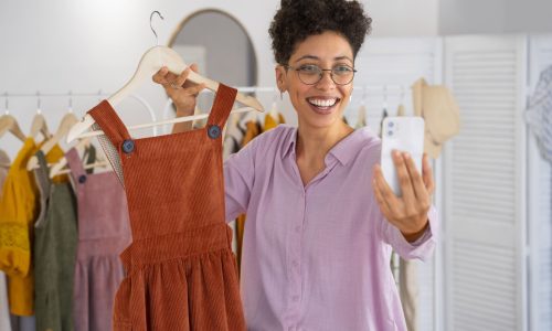 front-view-smiley-woman-presenting-clothes (1)